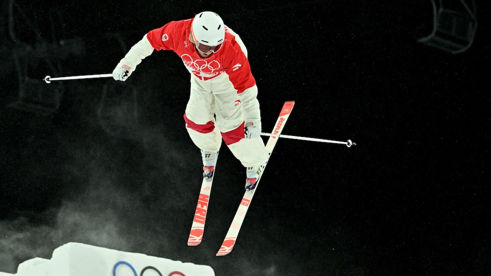 Une skieuse effectue un saut acrobatique.